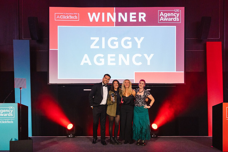 Ziggy Agency representatives posing with trophies beneath their winner announcement at the UK Agency Awards